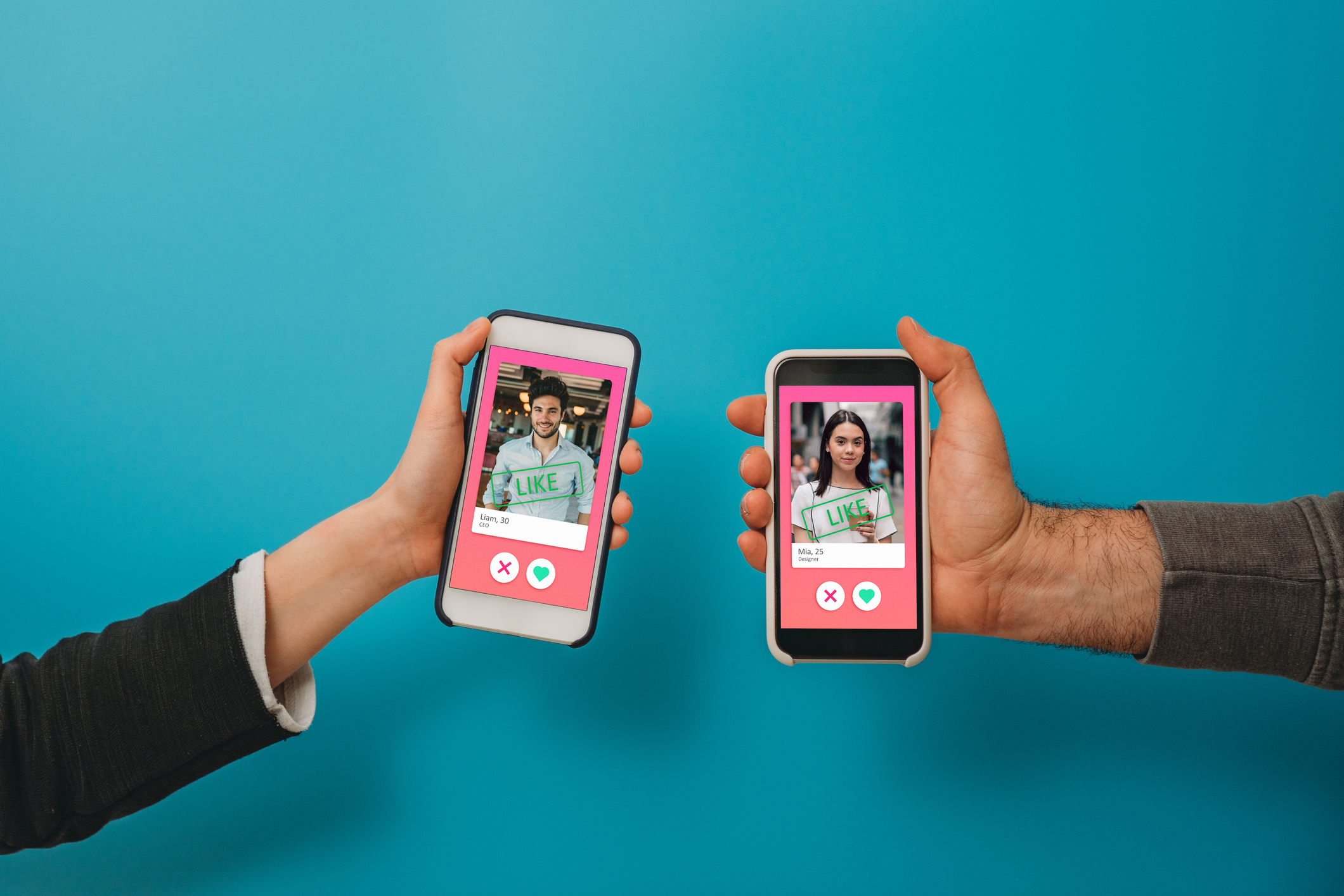 conceptual image of two hands holding smart phones with an online dating app on the screen