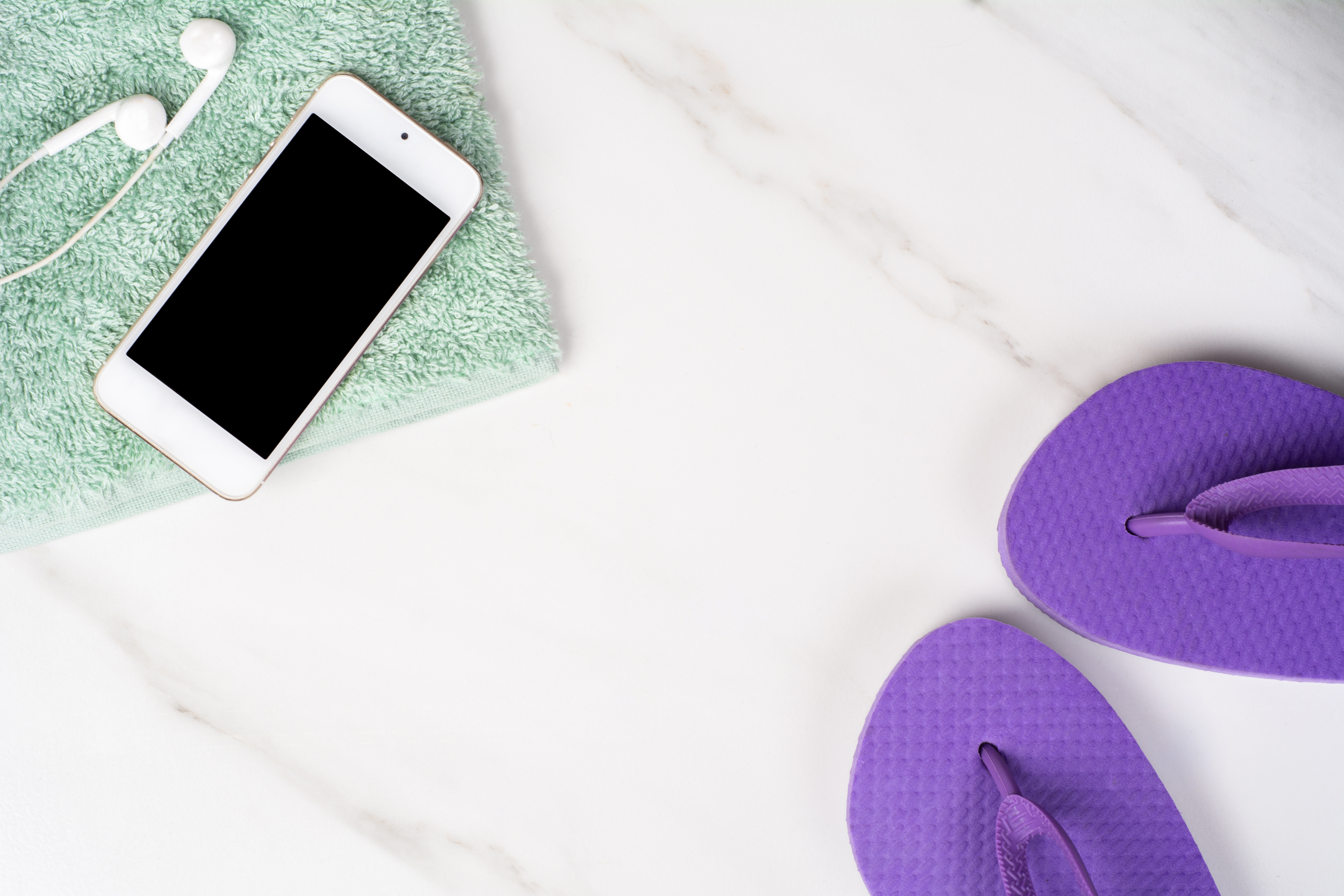 smartphone, flip flops and towel