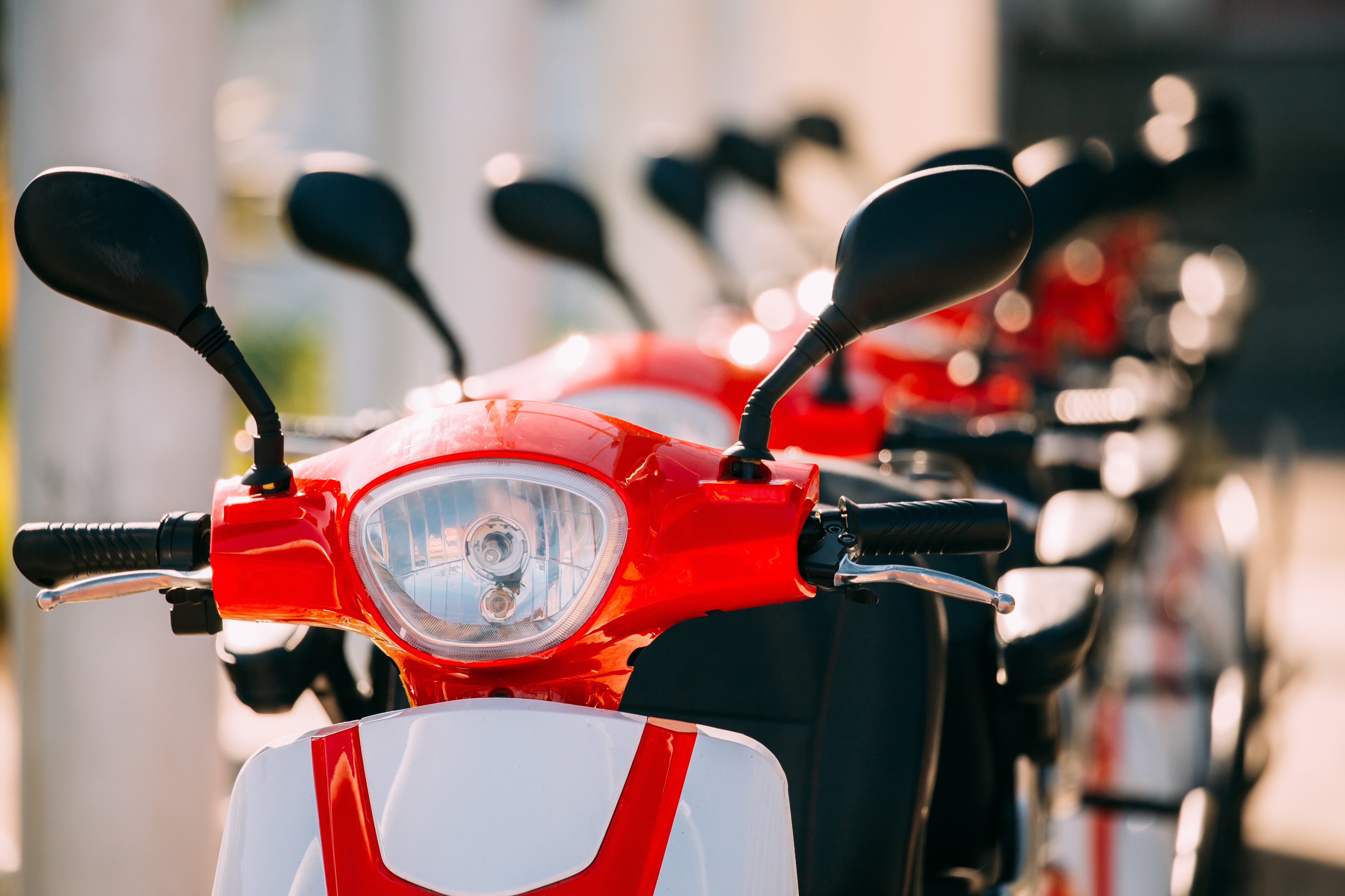 many electric motorbikes, motorcycles scooters parked in row in